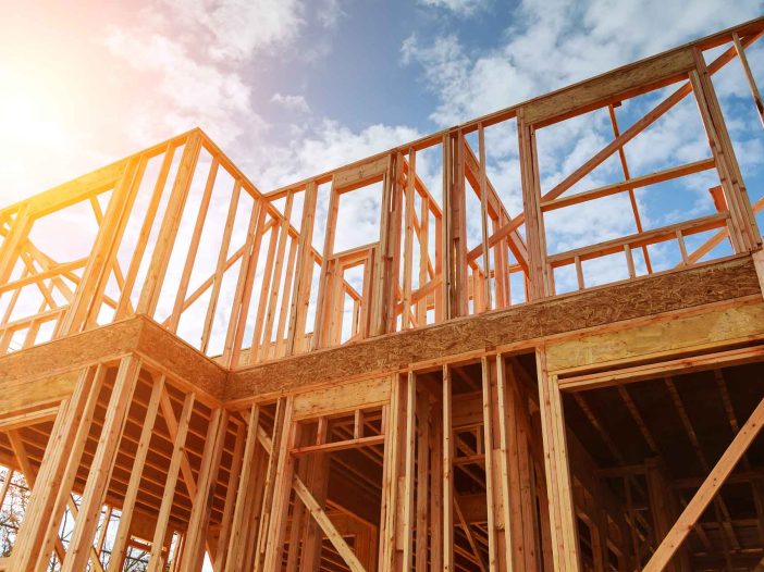 New residential construction home framing against a blue sky. Roofing construction. Wooden construction